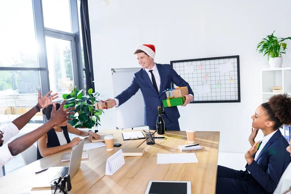 Businessman presenting gifts to colleagues — Stock Photo