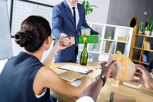 Hombre de negocios presentando regalos a colegas - foto de stock