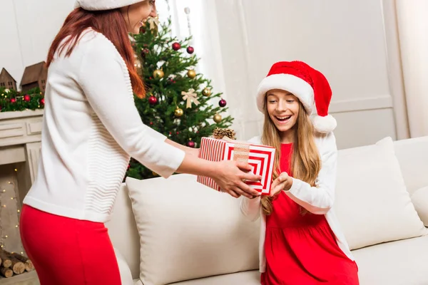 Madre presentando regalo de Navidad para la hija - foto de stock