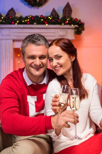 Pareja madura tintineo copas de champán - foto de stock