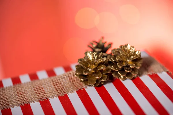 Boîte cadeau rayé avec des cônes de pin — Photo de stock