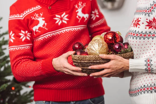 Pareja holding baubles - foto de stock