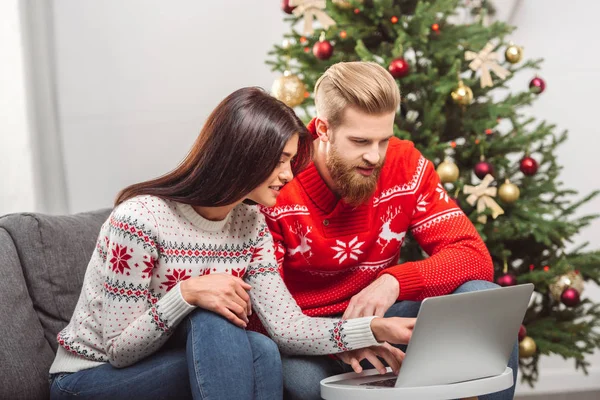 Pareja usando el ordenador portátil en Navidad - foto de stock