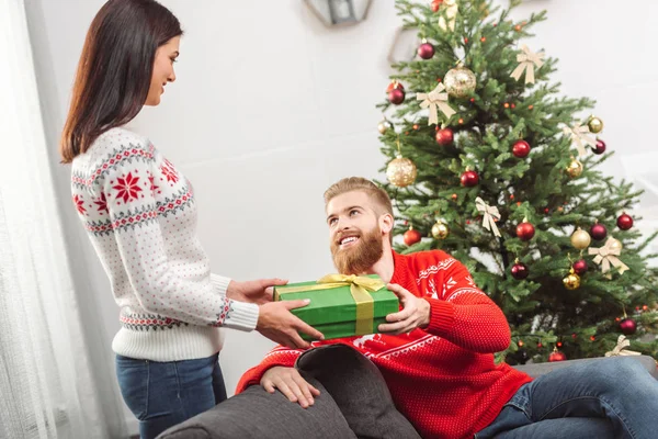 Girl presenting christmas gift to boyfriend — Stock Photo