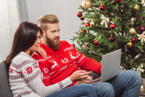 Pareja usando el ordenador portátil en Navidad - foto de stock