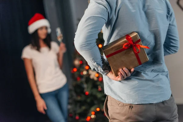 Мужчина преподносит рождественский подарок своей девушке — стоковое фото
