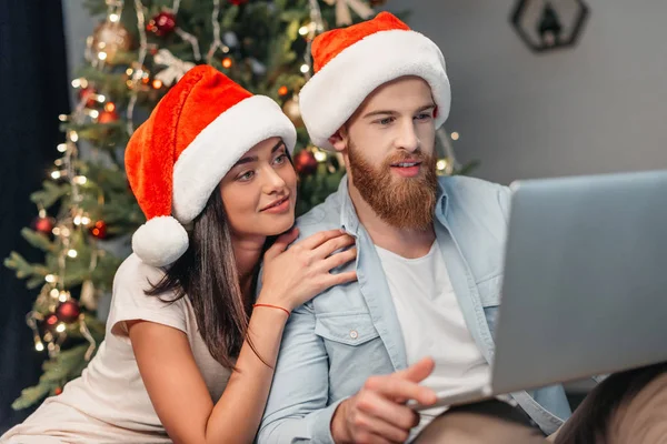 Pareja usando el ordenador portátil en la víspera de Navidad - foto de stock