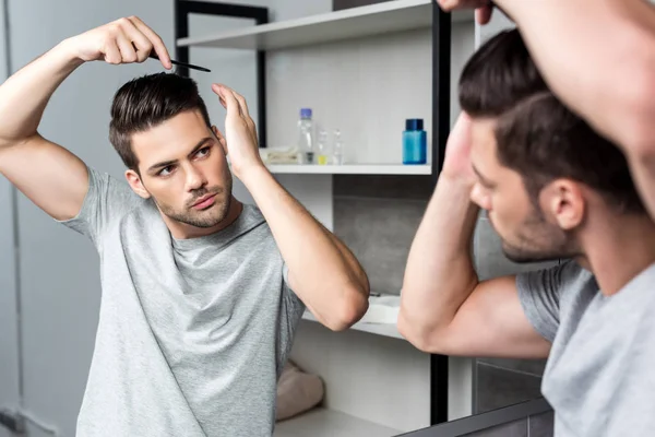 Jeune homme brossant les cheveux — Photo de stock