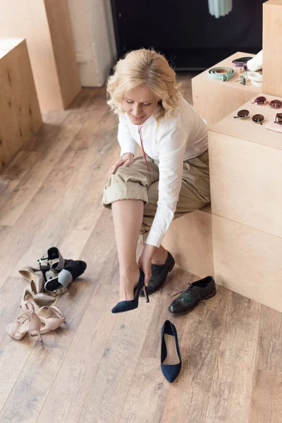 Femme essayer sur chaussures dans magasin de vêtements — Photo de stock