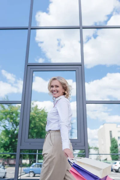 Mulher sorridente com sacos de compras — Fotografia de Stock