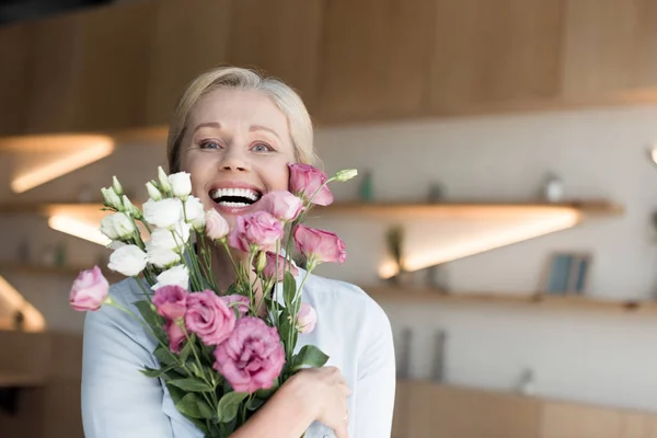 Mature woman with flowers — Stock Photo