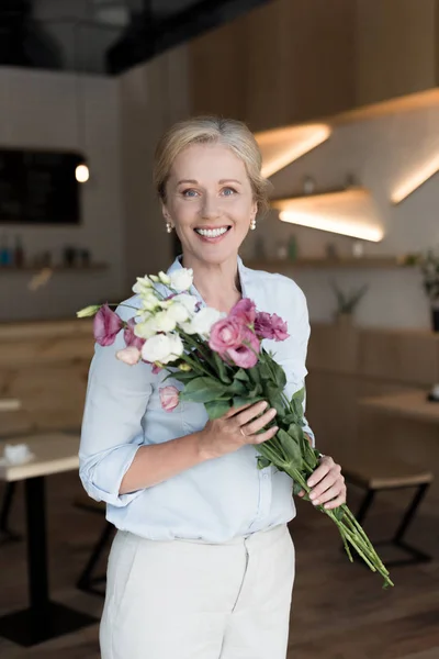 Mature woman with flowers — Stock Photo