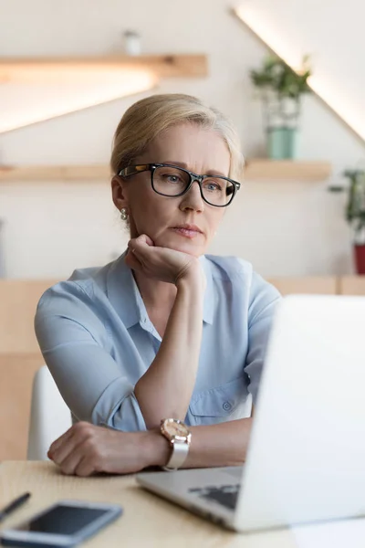 Donna matura utilizzando il computer portatile — Foto stock