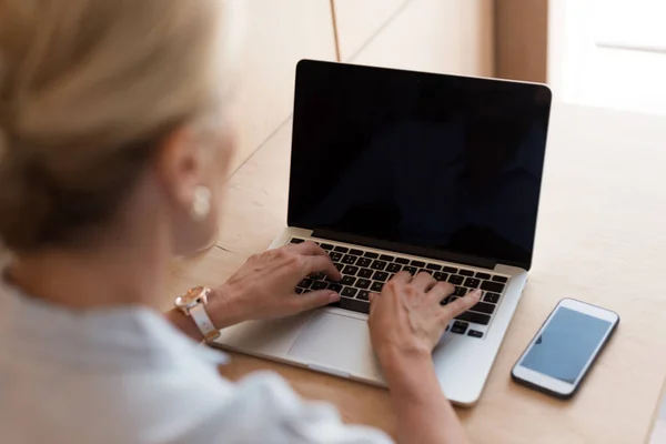 Mujer usando laptop y smartphone - foto de stock