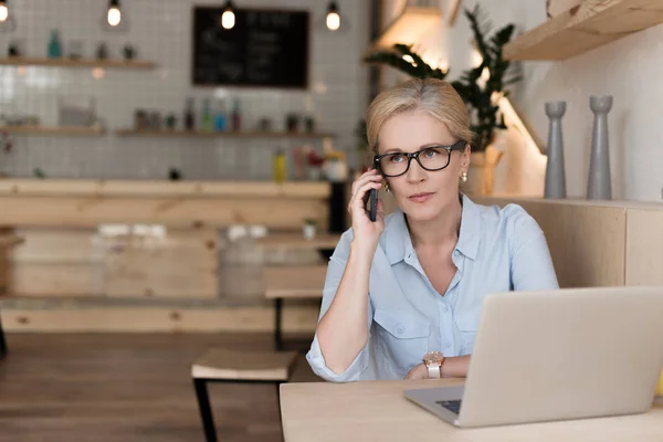Mujer de negocios con gadgets en la cafetería - foto de stock