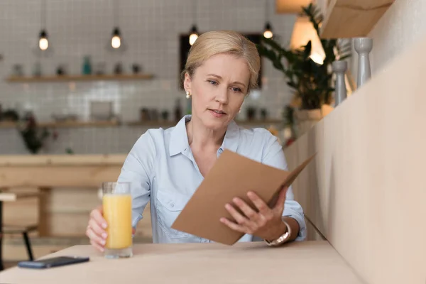 Menu de lecture femme au café — Photo de stock