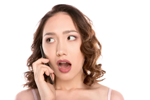 Shocked girl talking on smartphone — Stock Photo