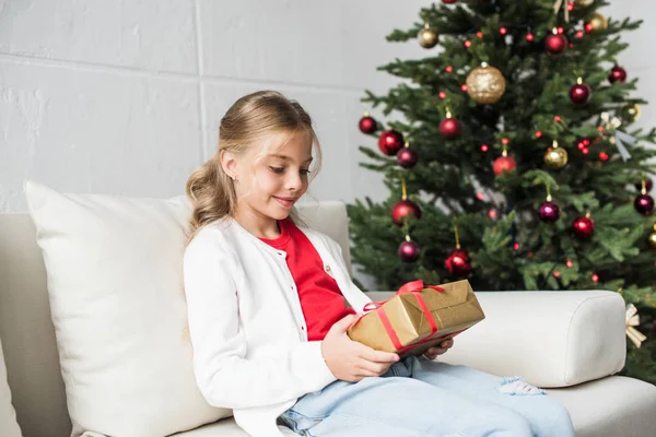 Kind hält Weihnachtsgeschenk in der Hand — Stockfoto