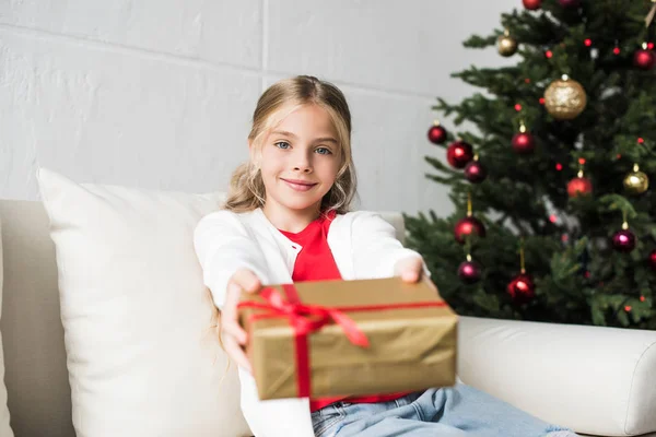 Kind hält Weihnachtsgeschenk in der Hand — Stockfoto