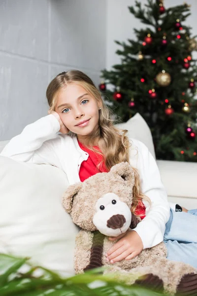 Niño con oso de peluche en el árbol de Navidad - foto de stock