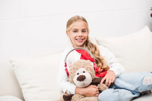 Enfant avec ours en peluche avec écouteurs — Photo de stock