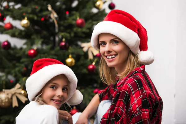 Mutter und Tochter in Weihnachtsmannmützen — Stockfoto