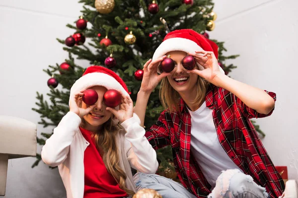 Mutter und Tochter in Weihnachtsmannmützen — Stockfoto