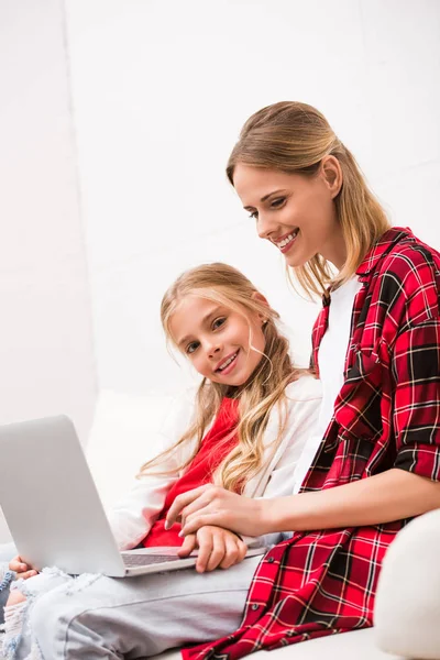 Madre e hija usando laptop - foto de stock