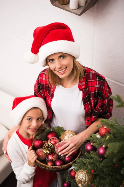 Mother and daughter decorating christmas tree — Stock Photo