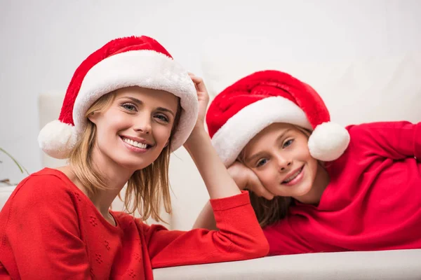 Mutter und Tochter in Weihnachtsmannmützen — Stockfoto