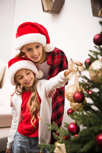 Mother and daughter decorating christmas tree — Stock Photo