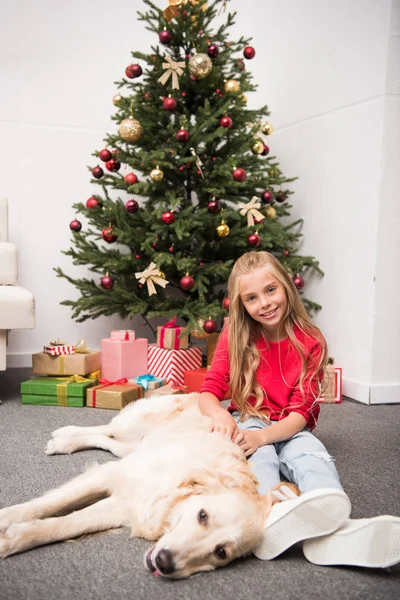 Niño con perro en el árbol de Navidad - foto de stock