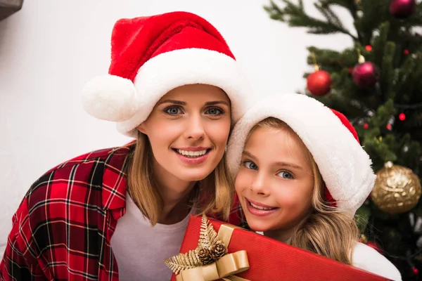 Mutter und Tochter in Weihnachtsmannmützen — Stockfoto