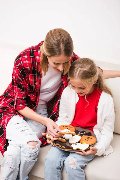 Mother and daughter with halloween cookies — Stock Photo