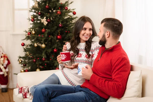 Pareja con tazas en Navidad - foto de stock