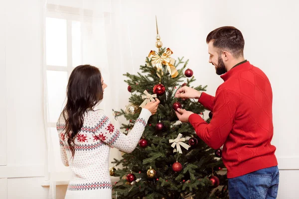 Paar schmückt Weihnachtsbaum — Stockfoto