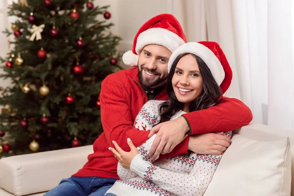 Pareja feliz en sombreros de santa - foto de stock