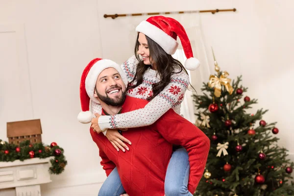 Casal feliz em chapéus de santa — Fotografia de Stock