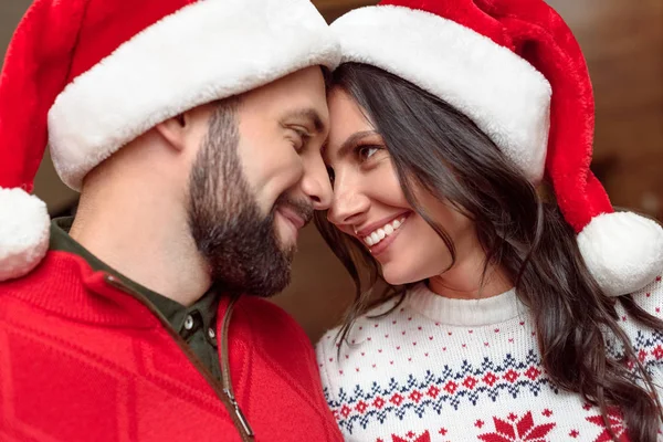 Pareja feliz en sombreros de santa - foto de stock