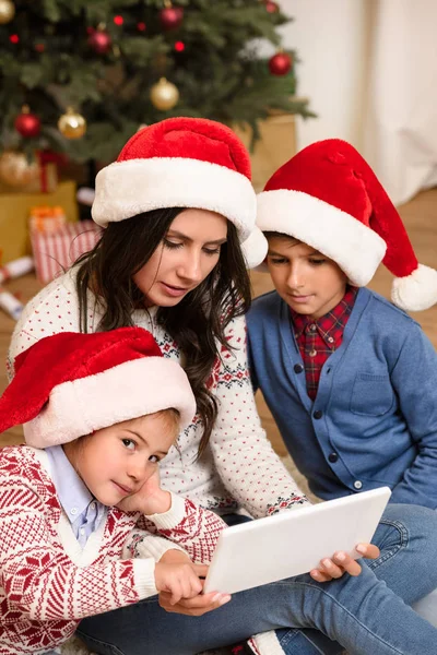 Familia con tableta digital en Navidad - foto de stock