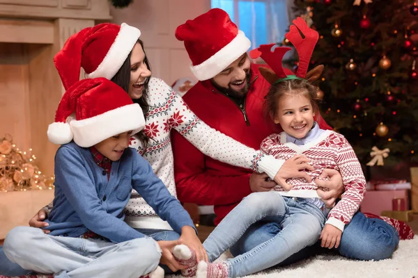 Glückliche Familie in Nikolausmützen — Stockfoto