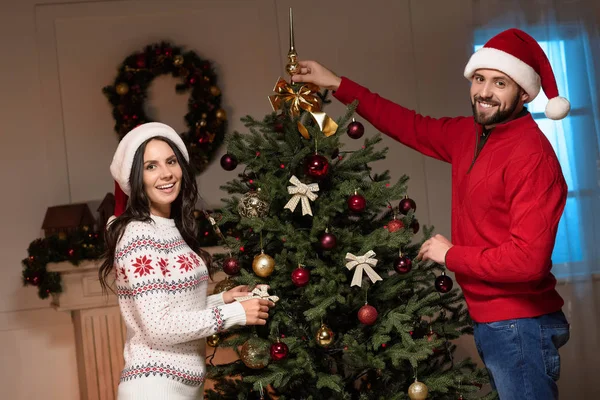 Paar schmückt Weihnachtsbaum — Stockfoto