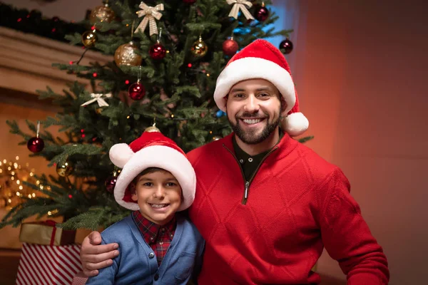 Vater und Sohn in Weihnachtsmützen — Stockfoto