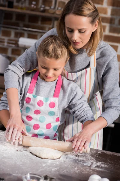 Мама помогает дочери с готовкой — стоковое фото