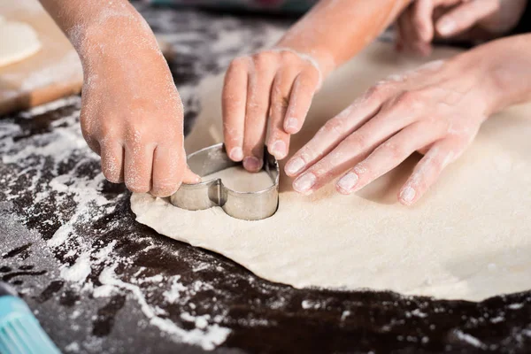 Family cutting out cookie — Stock Photo