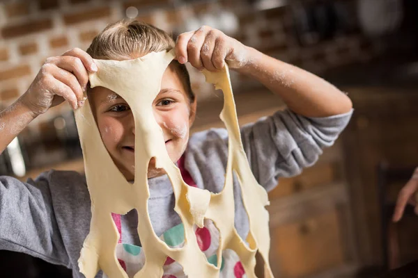 Smiling child with raw dough — Stock Photo