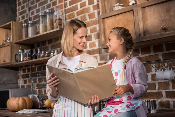 Family reading cookery book — Stock Photo