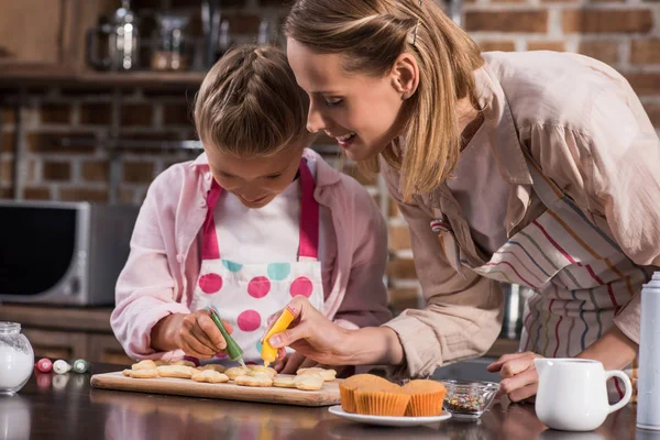 Family decorating cookies — Stock Photo