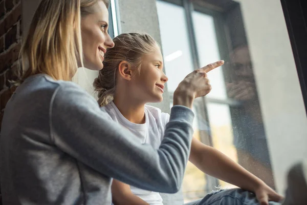 Familia mirando por la ventana - foto de stock