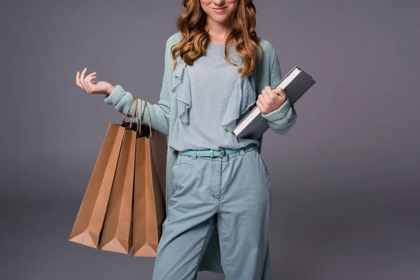 Fille avec livre et sacs à provisions — Photo de stock